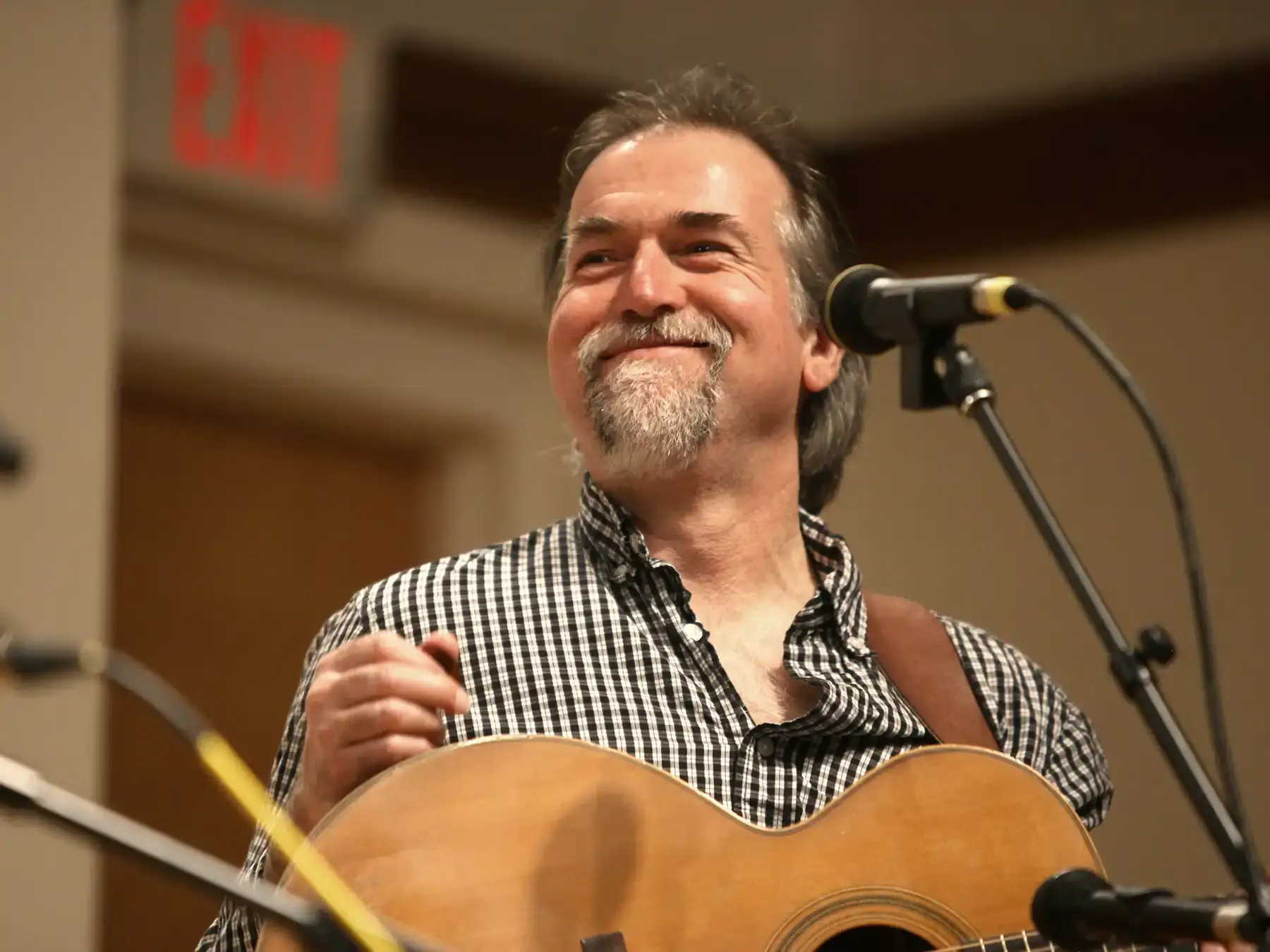 David Surette at a microphone with guitar