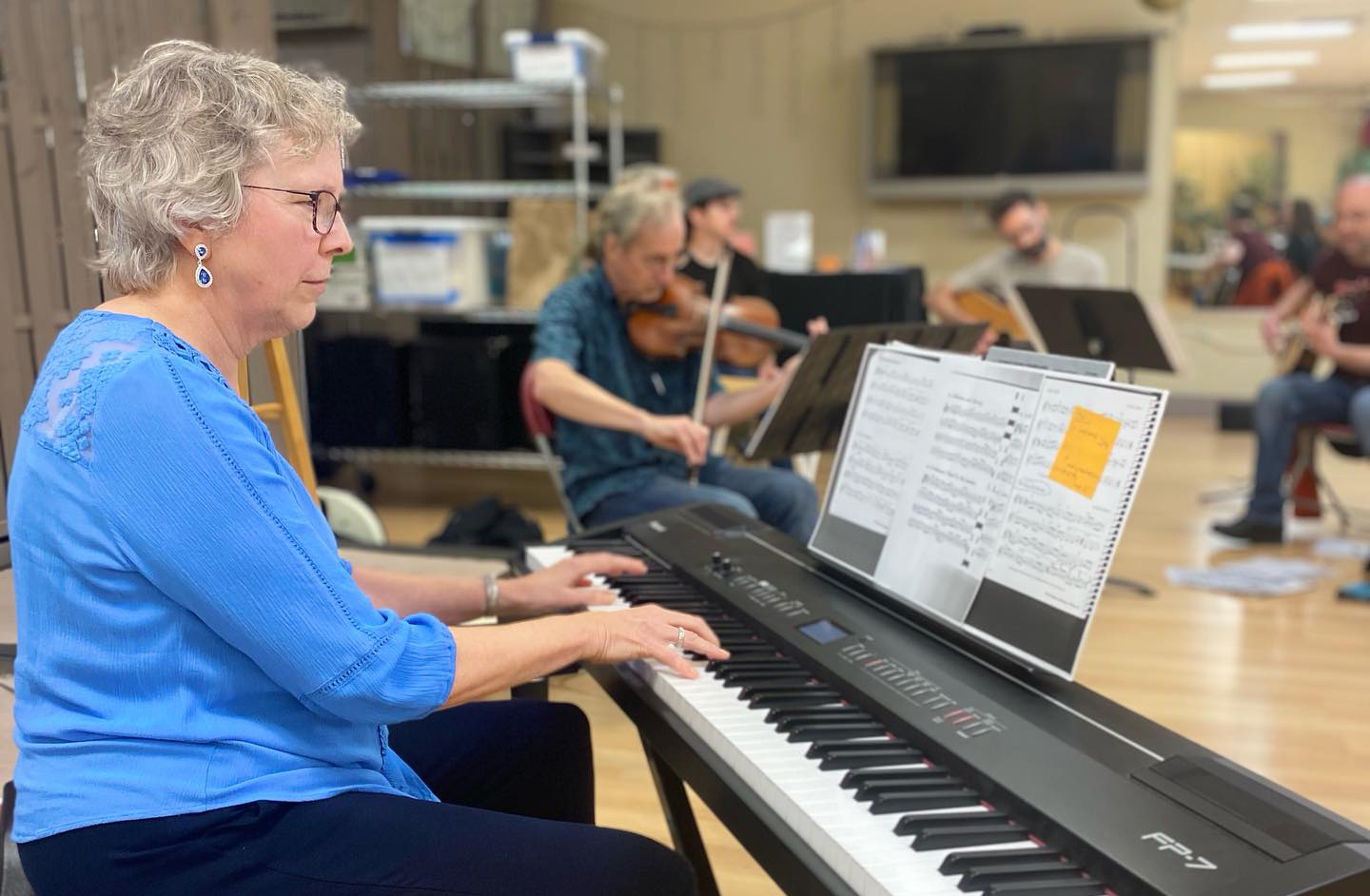 A person plays keyboard in a music workshop.