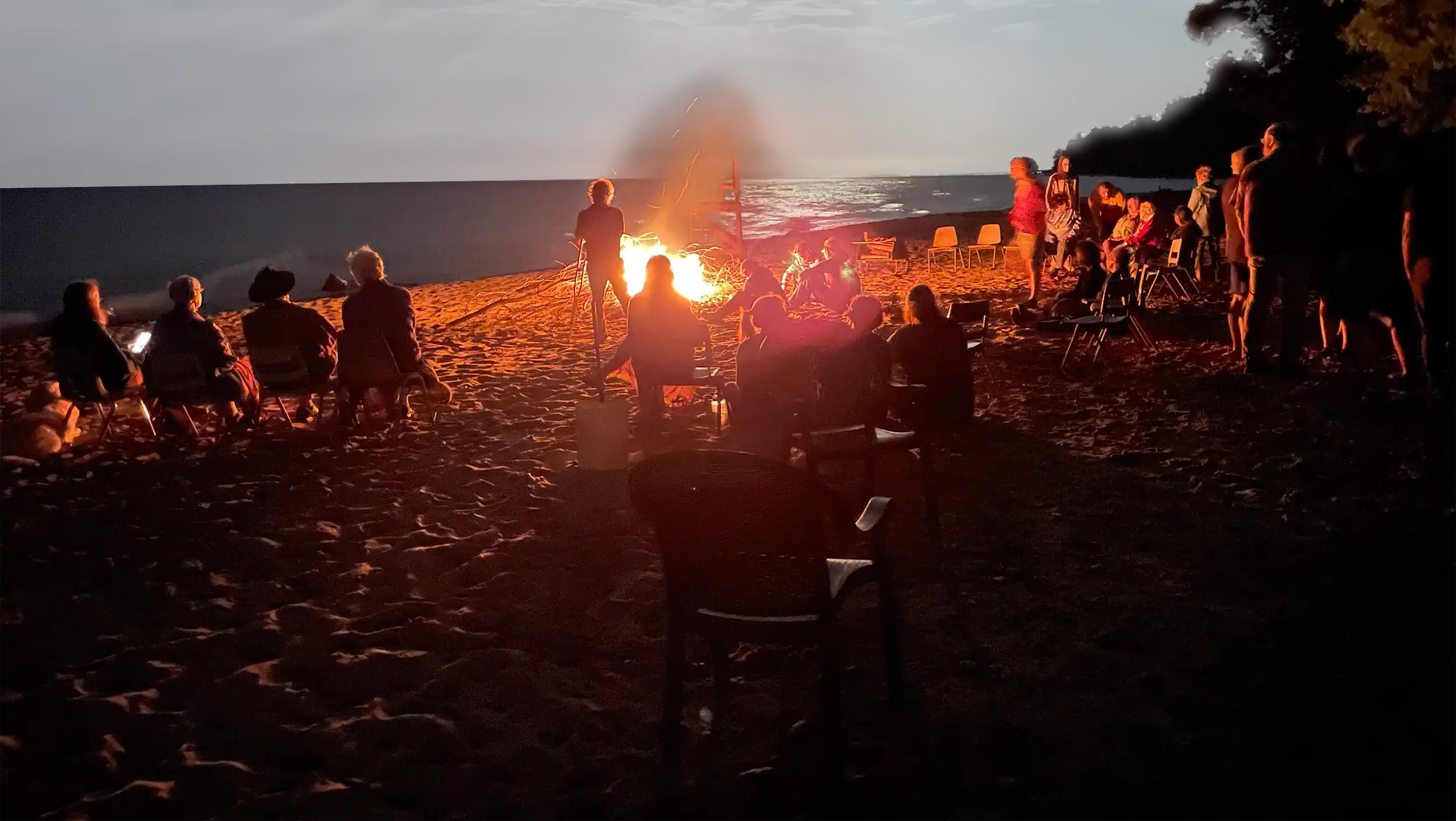 Campers around a lakeside campfire at Camp Cavell. Photo by Howard Carlberg.