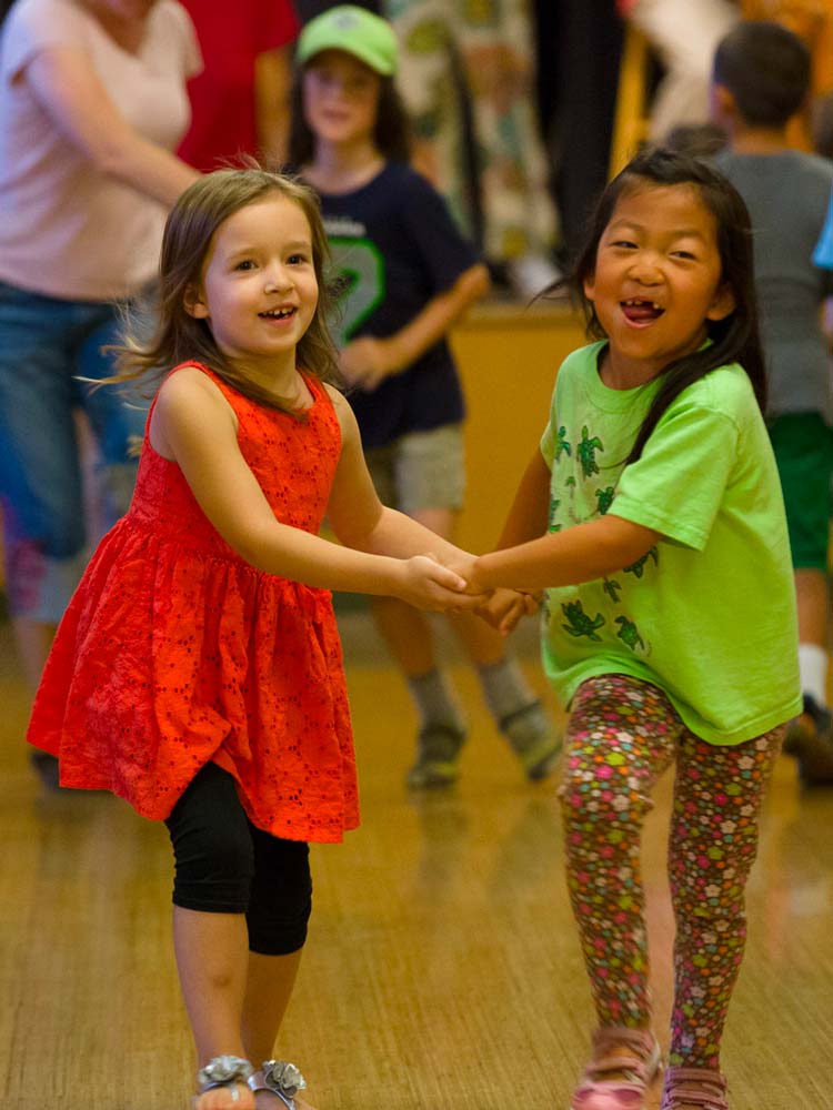 Elementary school kids holding hands in a dance