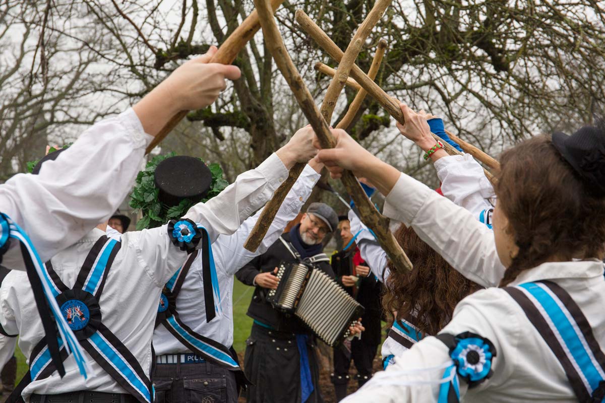 Morris dancers clapping sticks to the music of an accordion