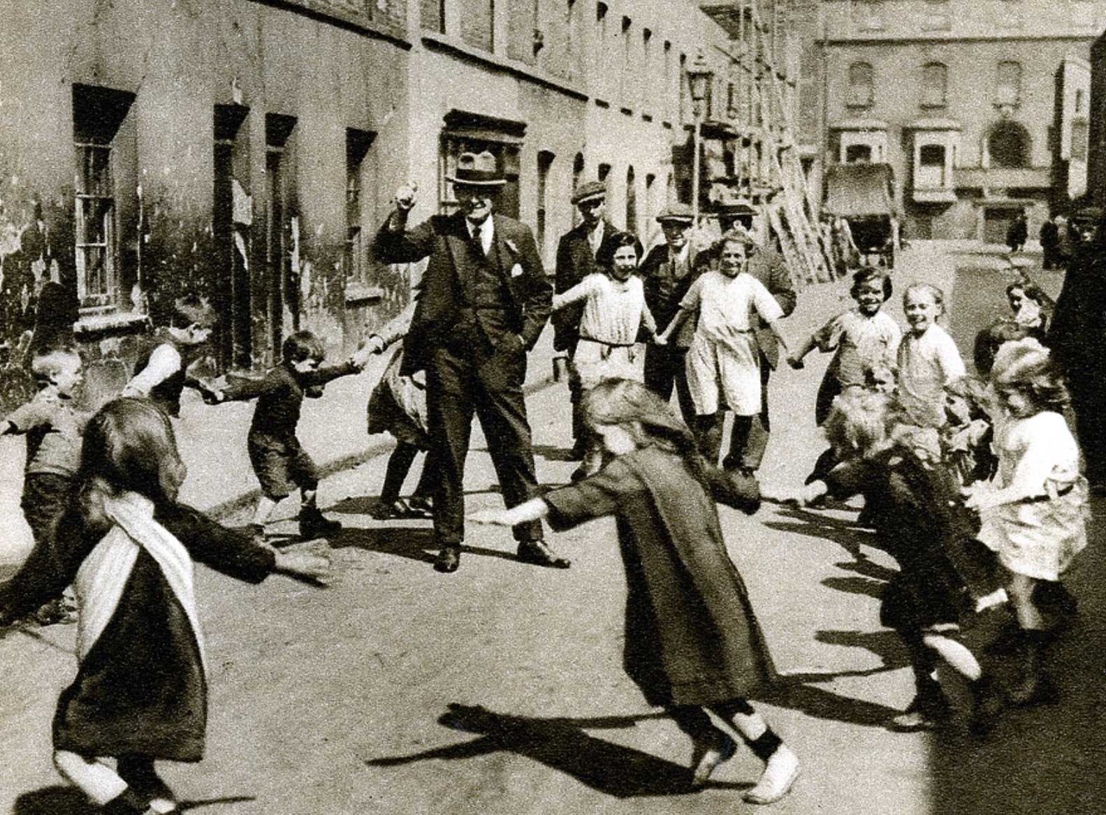 Children dance around a man in the street