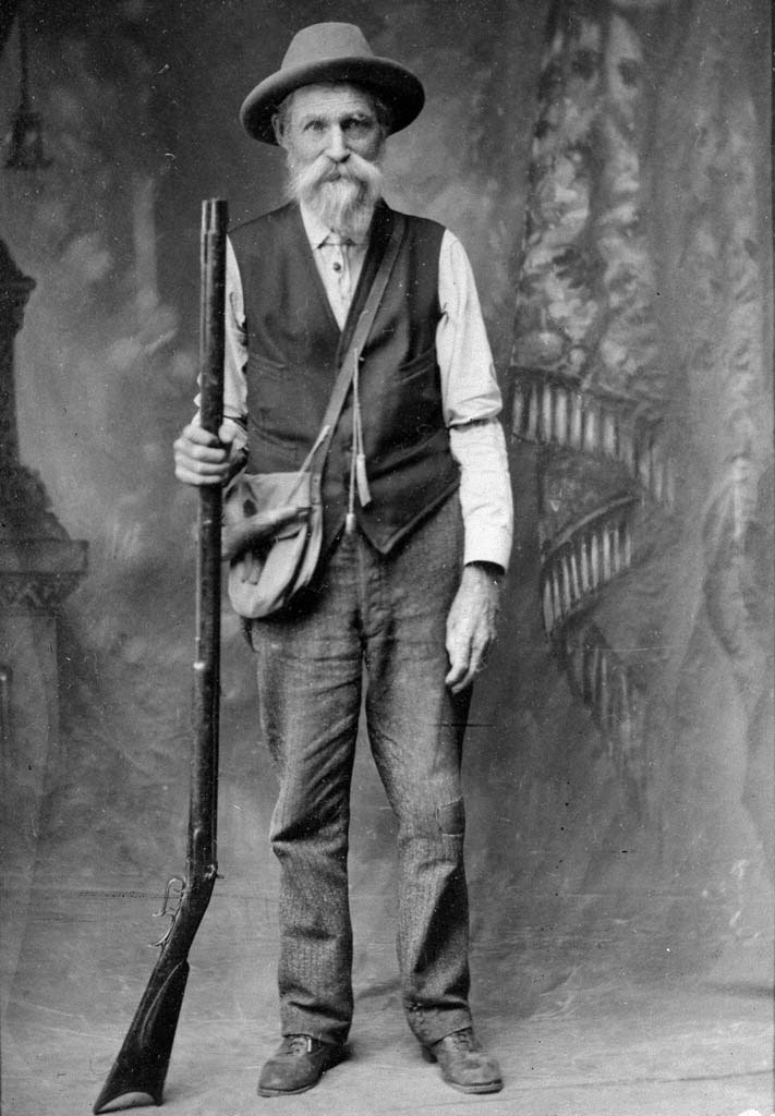 A thin homesteader holding a rifle
