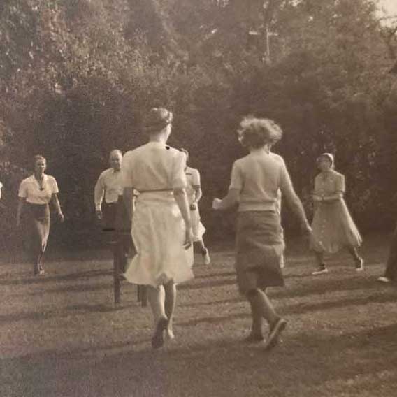 Sepia-toned photo of women dancing outdoors