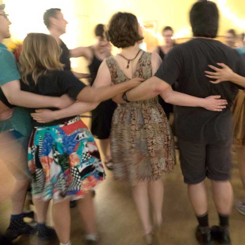 Younger dancers with their arms around each other